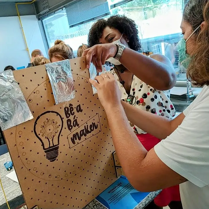 Educadoras montando um painel maker de papelão