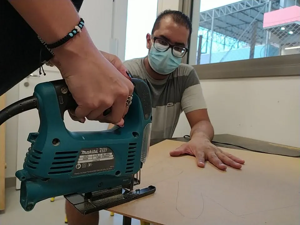 Educador orientando o uso de uma serra tico-tico